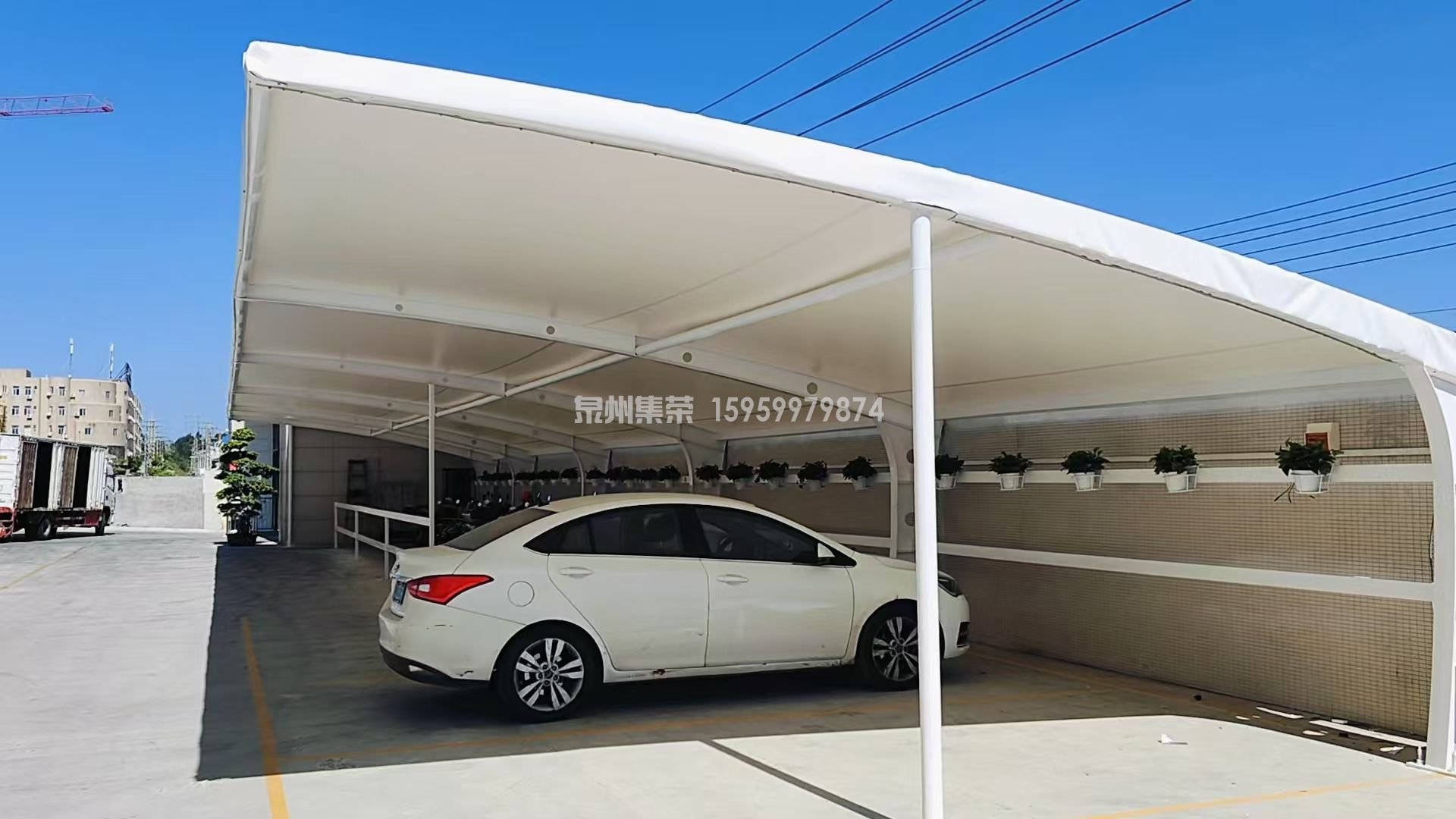 膜结构7字形案例图福建省泉州市石狮市鸿山镇祥华集团福祥印整仓库膜结构停车棚，总面积 326.3㎡，分双区域停放电动车与家用轿车，膜材防晒防雨，钢结构防腐工艺完善，工厂厂区配套遮阳棚完工实拍，泉州本地膜结构厂家官网：www.jirongcn.cn，咨询 15959979874